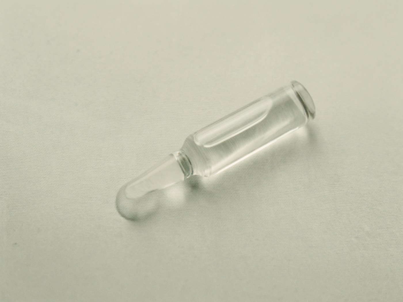 Szklana ampułka z serum na lnianej tkaninie